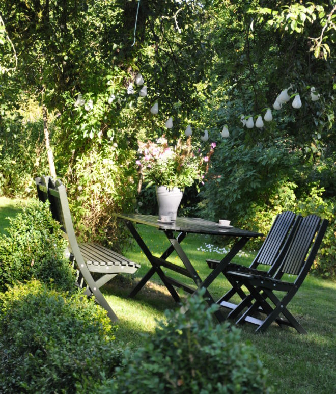 Frodigt sommargrönt med sittplats under päronträdet.