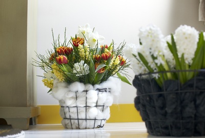Tulpaner i nätkorgar invändigt klädda med bomull skapar en ullig kontrast mellan de krispiga blommorna och den varma, mjuka bomullen. 